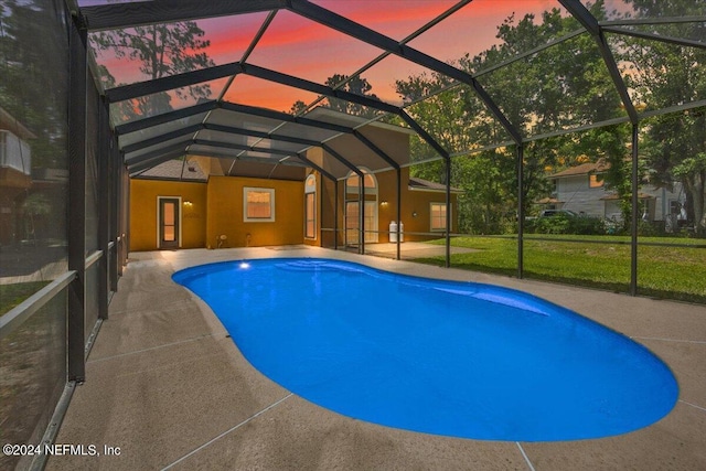 pool with a lanai, a patio area, and a yard