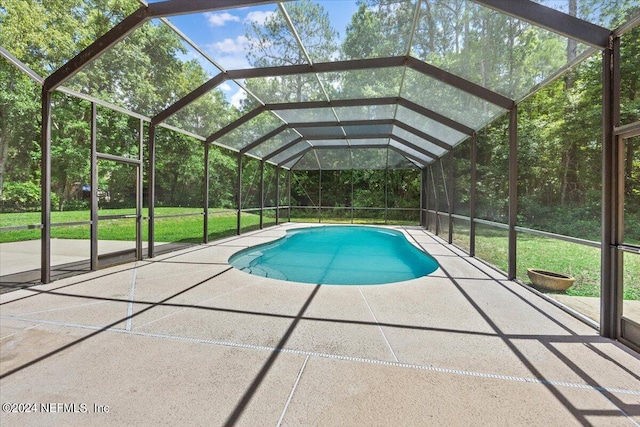 outdoor pool with a patio, a lawn, and a lanai