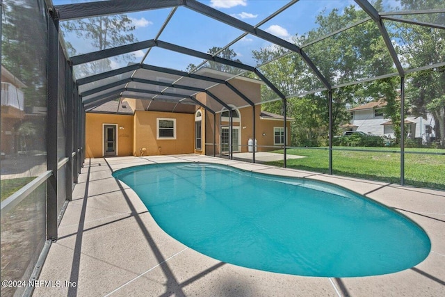 pool with a lanai, a patio, and a lawn