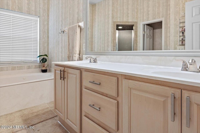 bathroom with double vanity, tile patterned floors, a sink, and wallpapered walls