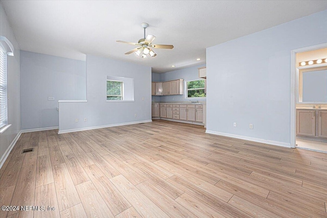 unfurnished living room featuring a ceiling fan, visible vents, light wood-style flooring, and baseboards