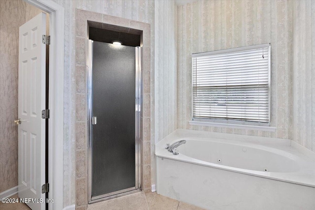 bathroom with a tub with jets, a stall shower, tile patterned floors, and wallpapered walls