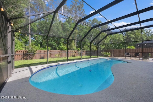 view of swimming pool with a lanai, a lawn, and a patio