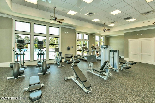 workout area featuring ceiling fan, a drop ceiling, and ornamental molding