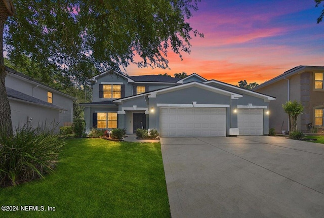 view of front of property with a yard and a garage