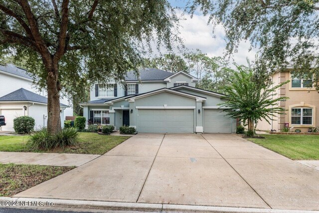 view of property featuring a garage and a front yard