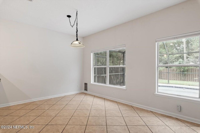 spare room featuring plenty of natural light and light tile patterned flooring