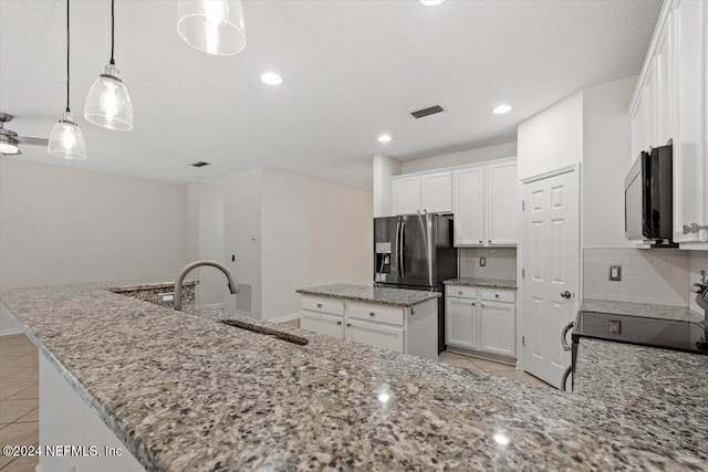 kitchen featuring decorative backsplash, a kitchen island with sink, sink, pendant lighting, and white cabinets