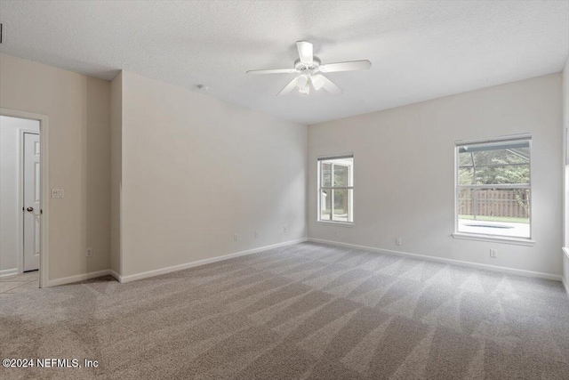 carpeted spare room with a textured ceiling and ceiling fan