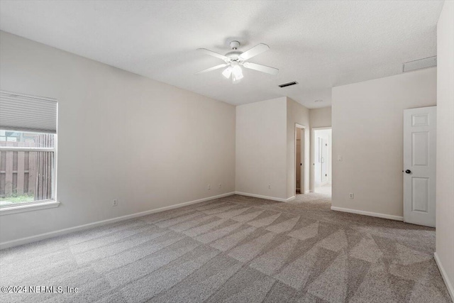 unfurnished room featuring light carpet, a textured ceiling, and ceiling fan