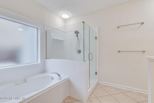 bathroom with tile patterned flooring, shower with separate bathtub, and a textured ceiling