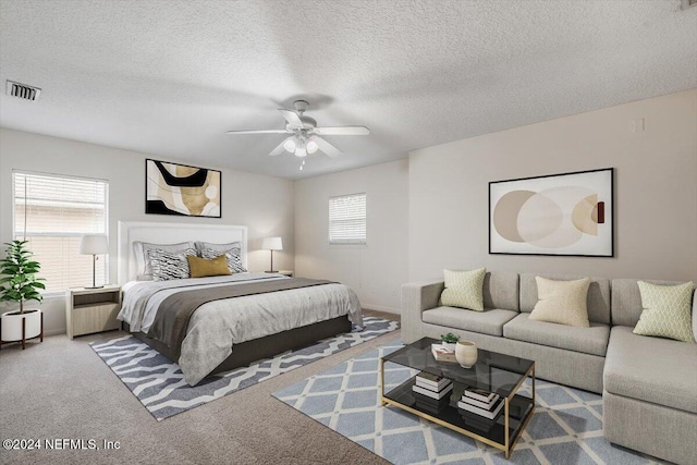 bedroom featuring carpet flooring, ceiling fan, and a textured ceiling