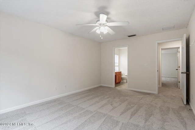 unfurnished bedroom featuring ensuite bath, ceiling fan, and light carpet