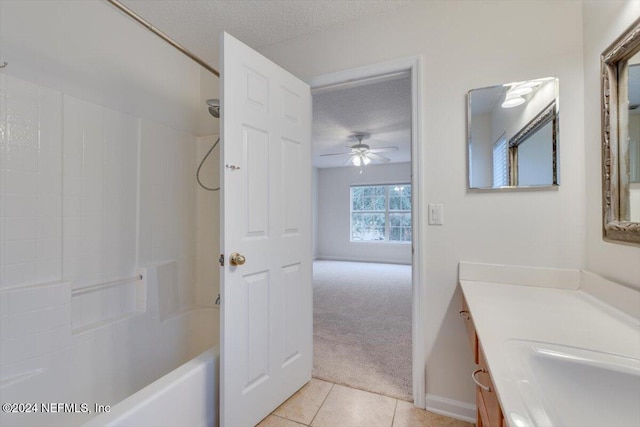 bathroom with ceiling fan, tile patterned floors, a textured ceiling, vanity, and bathtub / shower combination