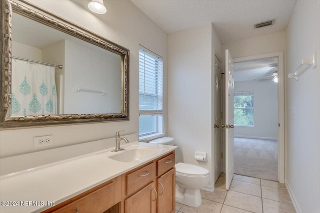 bathroom featuring vanity, tile patterned flooring, ceiling fan, toilet, and a textured ceiling