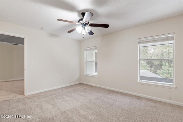 carpeted empty room with a textured ceiling and ceiling fan