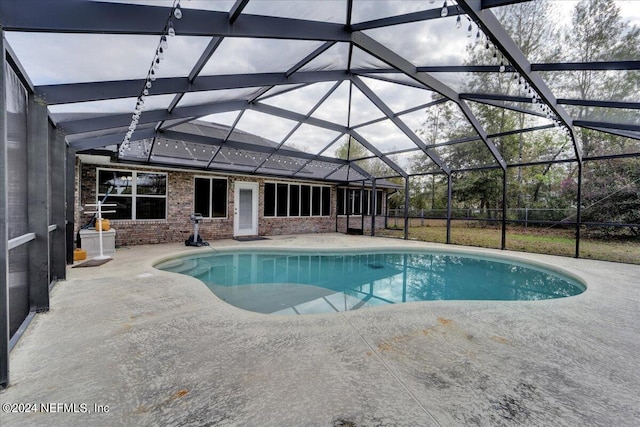 view of swimming pool with glass enclosure and a patio