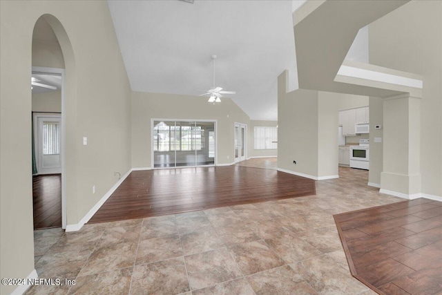 unfurnished living room with high vaulted ceiling, light hardwood / wood-style floors, and ceiling fan