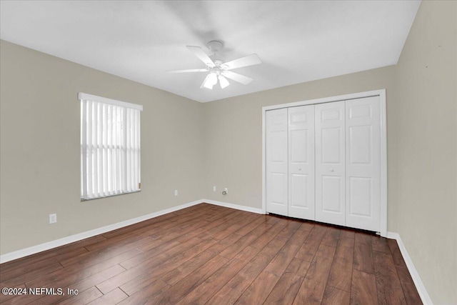 unfurnished bedroom with a closet, ceiling fan, and dark hardwood / wood-style flooring