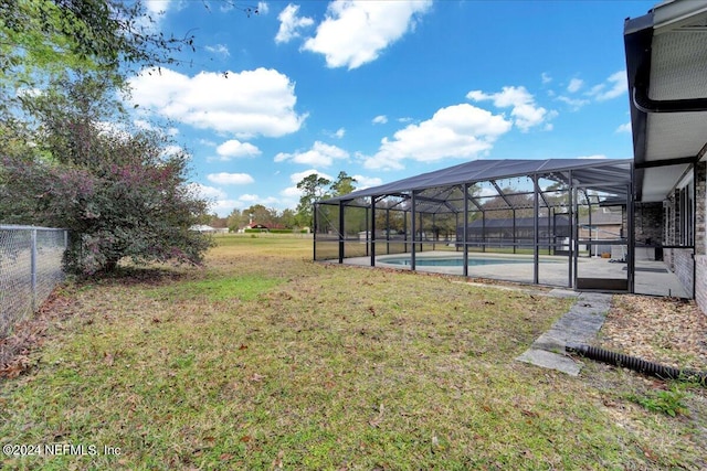 view of yard featuring glass enclosure and a patio