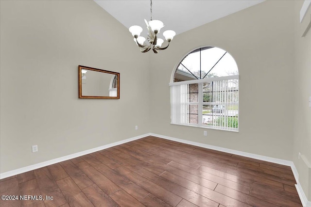 empty room with dark wood-type flooring, a chandelier, and lofted ceiling