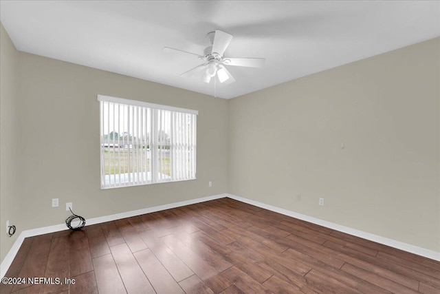 empty room with dark hardwood / wood-style flooring and ceiling fan