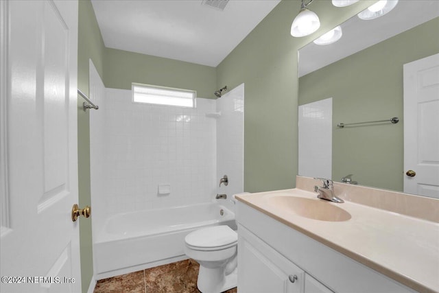 full bathroom featuring toilet, vanity with extensive cabinet space, tile floors, and tiled shower / bath combo