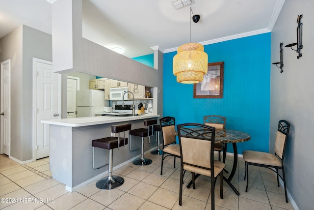 dining area with sink, crown molding, and light tile patterned floors