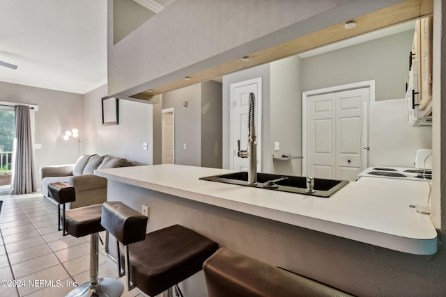 kitchen featuring a breakfast bar, white refrigerator, and light tile patterned floors