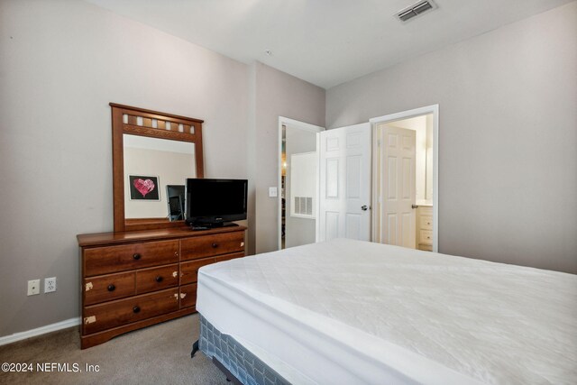 bedroom featuring light colored carpet and ensuite bath