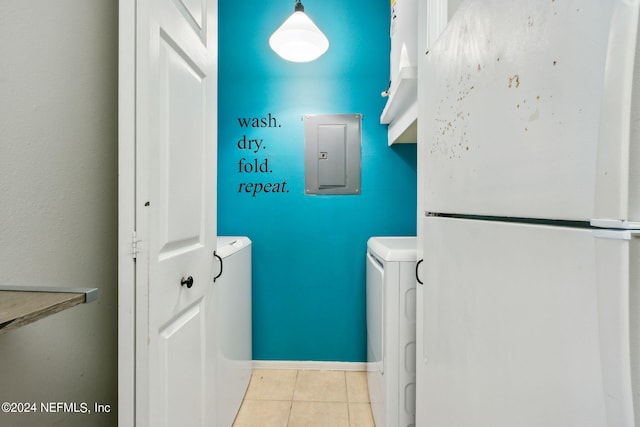 laundry room with light tile patterned floors, electric panel, and washer and clothes dryer