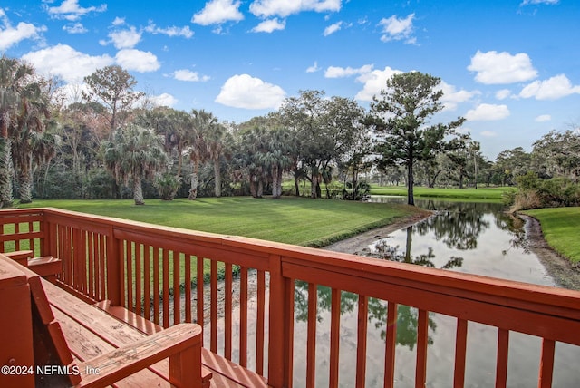 wooden terrace with a water view and a yard