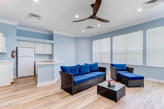 living room with light hardwood / wood-style flooring, ceiling fan, ornamental molding, and sink