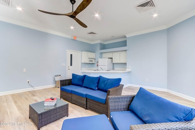 living room featuring light hardwood / wood-style flooring, ceiling fan, and ornamental molding