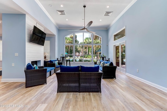 living room featuring light hardwood / wood-style flooring, a fireplace, and crown molding