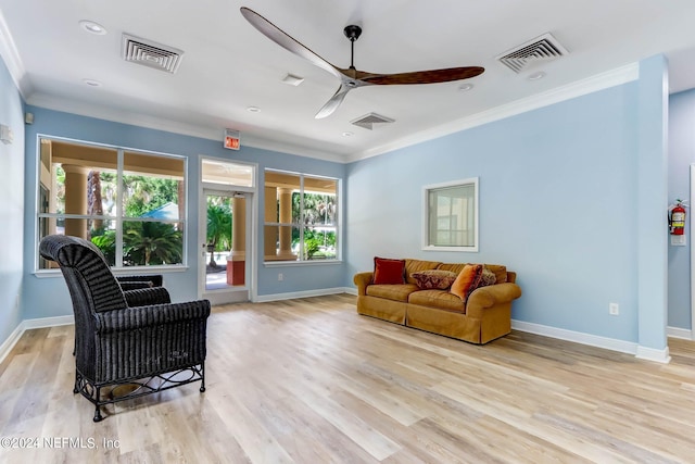 living room featuring ceiling fan, ornamental molding, light hardwood / wood-style floors, and a wealth of natural light