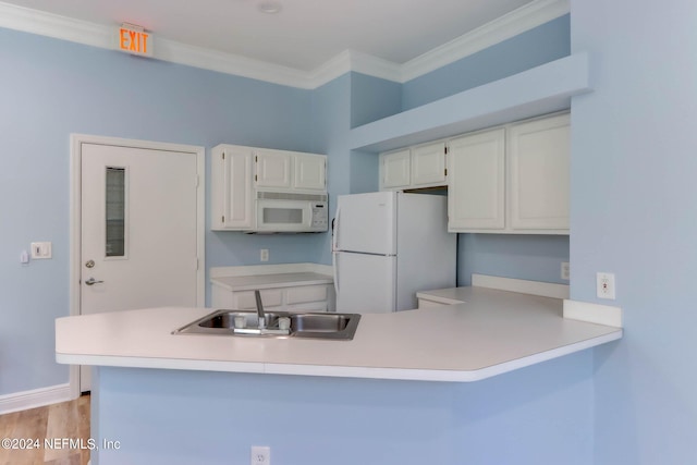 kitchen with white cabinets, white appliances, kitchen peninsula, ornamental molding, and sink