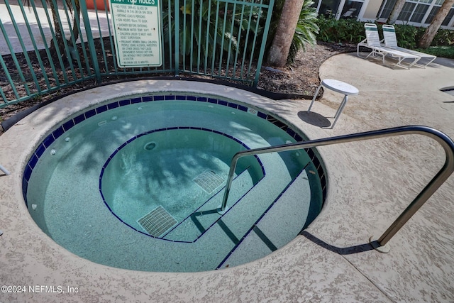 view of swimming pool with a hot tub