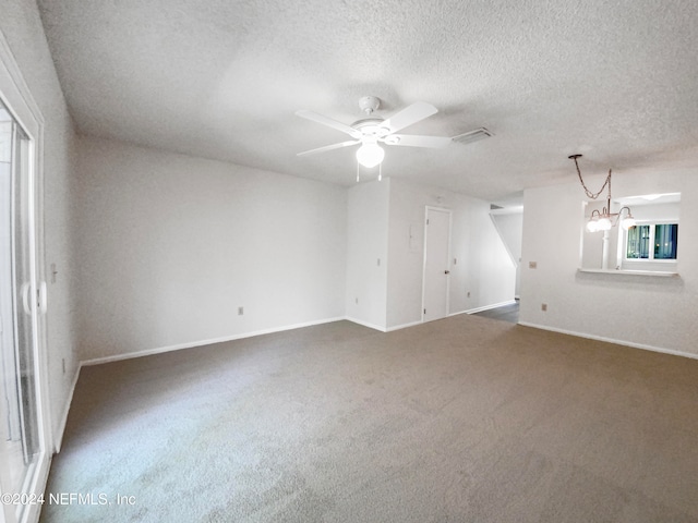 carpeted spare room featuring a textured ceiling and ceiling fan with notable chandelier