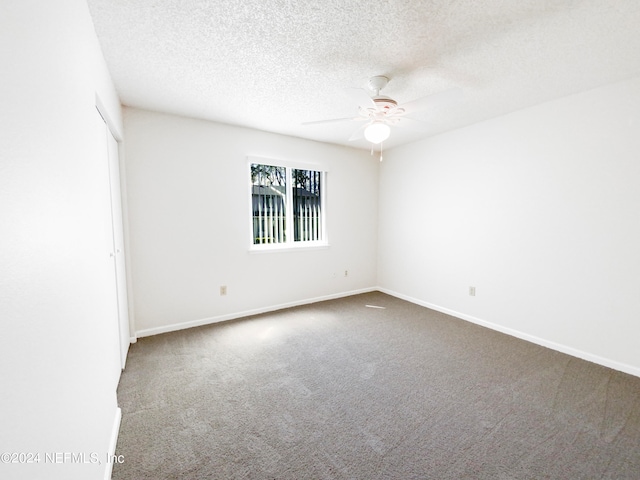 carpeted spare room with a textured ceiling and ceiling fan