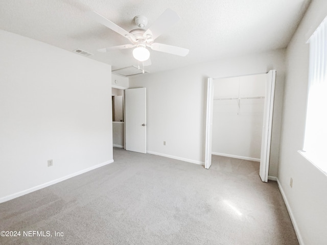 unfurnished bedroom with a closet, light carpet, and ceiling fan