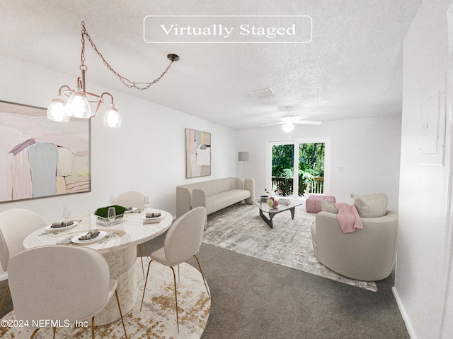 carpeted dining room featuring a textured ceiling and ceiling fan with notable chandelier