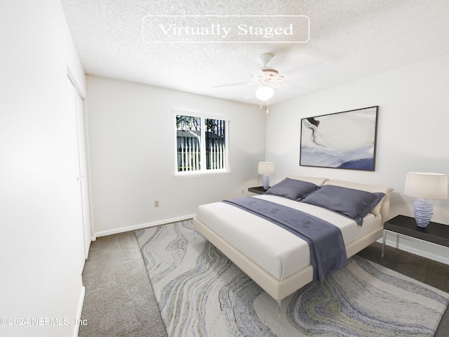 bedroom featuring light carpet, a closet, ceiling fan, and a textured ceiling