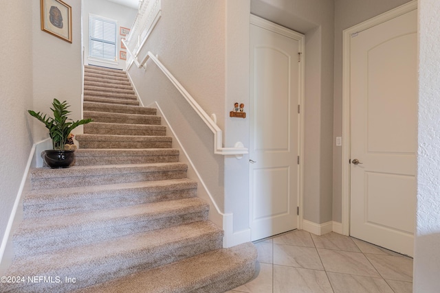 staircase featuring tile patterned flooring