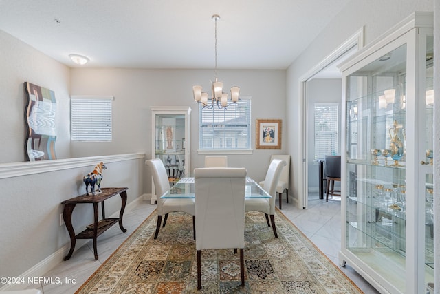 tiled dining area featuring a chandelier