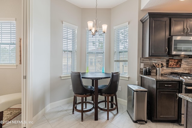 dining space with light tile patterned floors, a wealth of natural light, and a chandelier