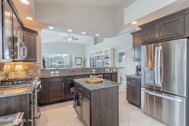 kitchen with a kitchen island, appliances with stainless steel finishes, tasteful backsplash, sink, and kitchen peninsula