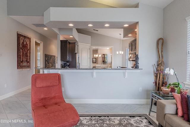 kitchen with dark brown cabinets, a kitchen bar, kitchen peninsula, and hanging light fixtures