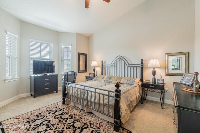 bedroom featuring ceiling fan, vaulted ceiling, and light carpet