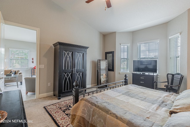 bedroom featuring light carpet, lofted ceiling, and ceiling fan